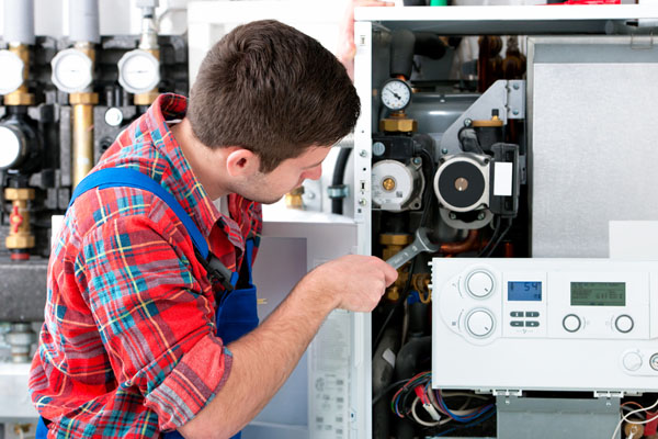 Heating technician repairing boiler controls in Moorpark