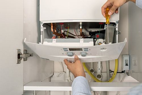 Heating technician repairing a residential boiler in Moorpark