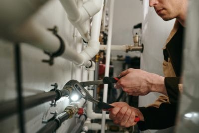 Technician inspecting commercial plumbing pipes in Moorpark
