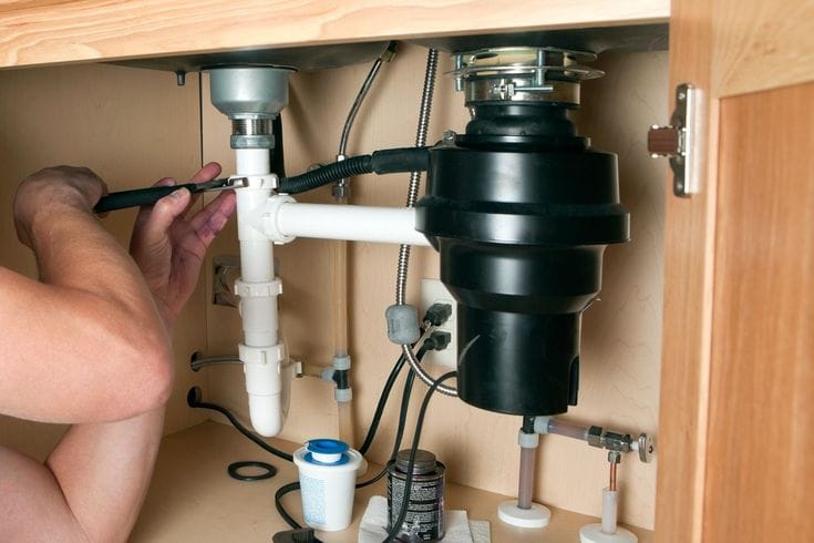 Plumber repairing a garbage disposal in Moorpark